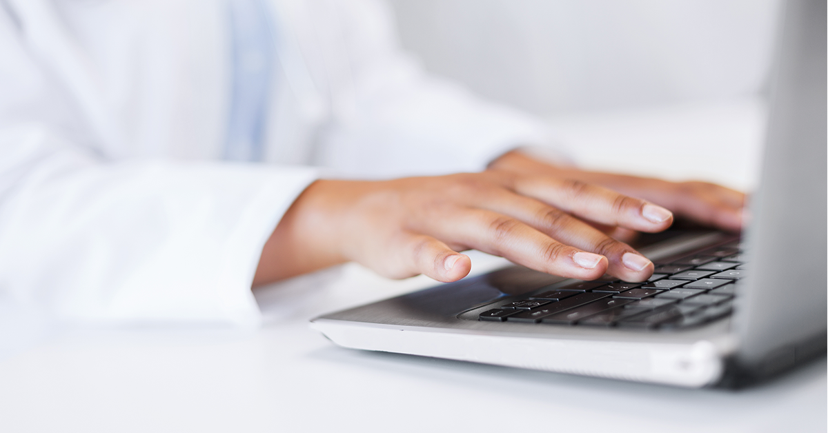 doctor typing on laptop